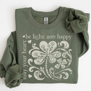 May include: A green sweatshirt with a white clover design and the text "may your heart be light and happy".
