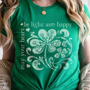 May include: Green t-shirt with a white shamrock design and the text "may your heart be light and happy".