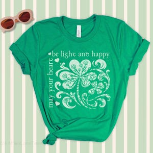 May include: Green t-shirt with a white shamrock design and the text "may your heart be light and happy".