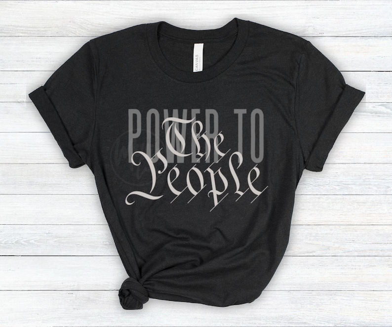 May include: Black t-shirt with the text "Power to the People" in a white, stylized font.