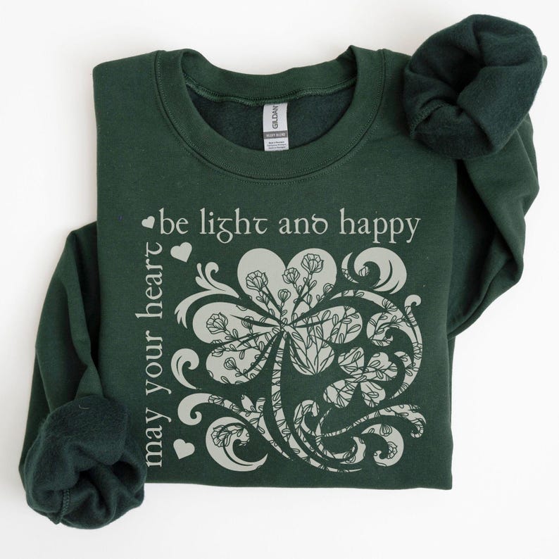May include: A dark green sweatshirt with a white shamrock design and the text "may your heart be light and happy".