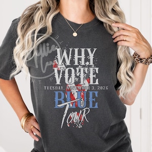 Op de afbeelding: Donkergrijs t-shirt met de tekst "WHY VOTE" in wit, rood en blauw. De tekst "TUESDAY, NOVEMBER 3, 2026" staat onder de woorden "WHY VOTE". Het woord "BLUE" is blauw en het woord "TOUR" is rood.