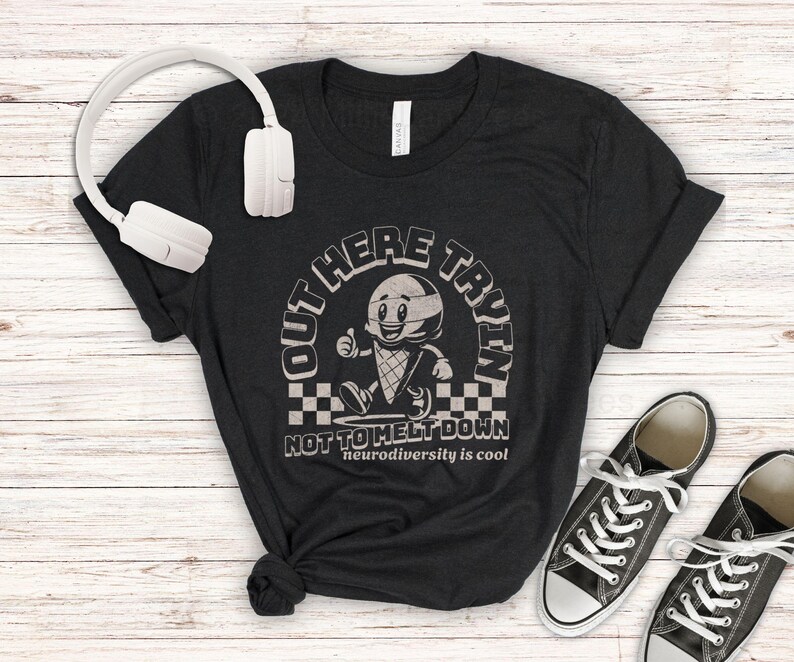 Puede incluir: Camiseta negra con un gr&aacute;fico blanco de un cono de helado con una cara y el texto "Out Here Tryin' Not To Melt Down Neurodiversity is cool".