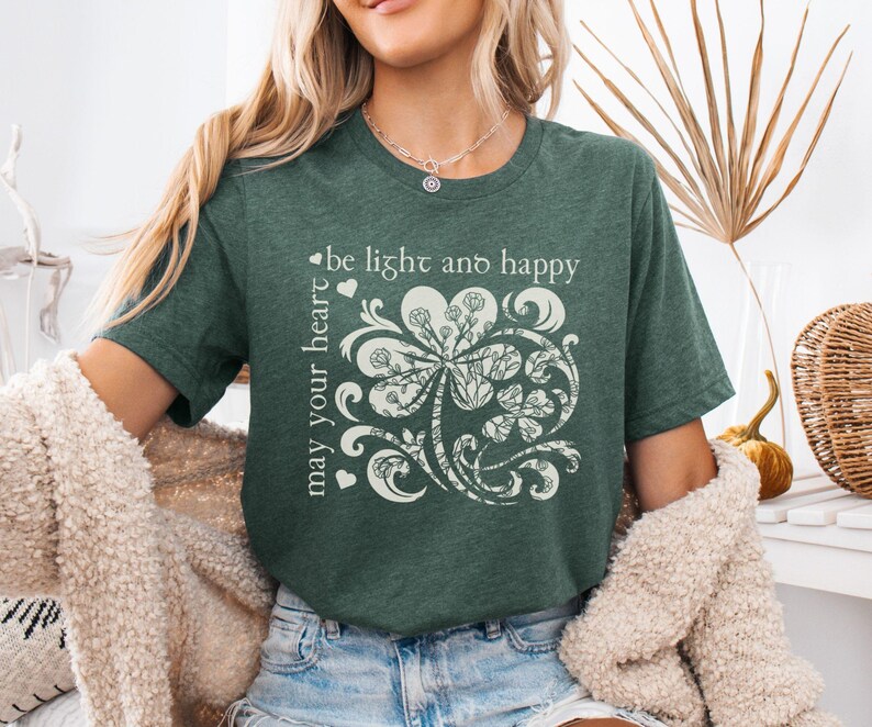 May include: A green t-shirt with a white shamrock design and the text "may your heart be light and happy".