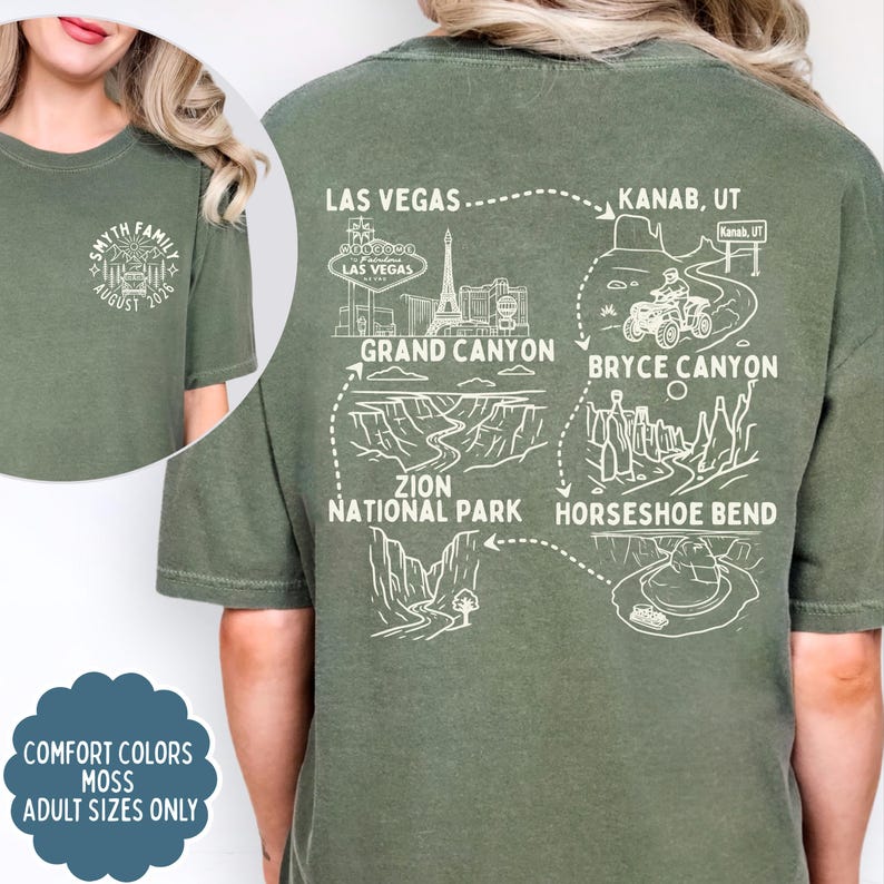 May include: Moss green t-shirt with a white graphic of a family crest and the text "SMYTH FAMILY AUGUST 2026" on the front. The back features a travel route map with landmarks like the Grand Canyon and Las Vegas. "Comfort Colors" and "Adult Sizes Only" are also displayed.
