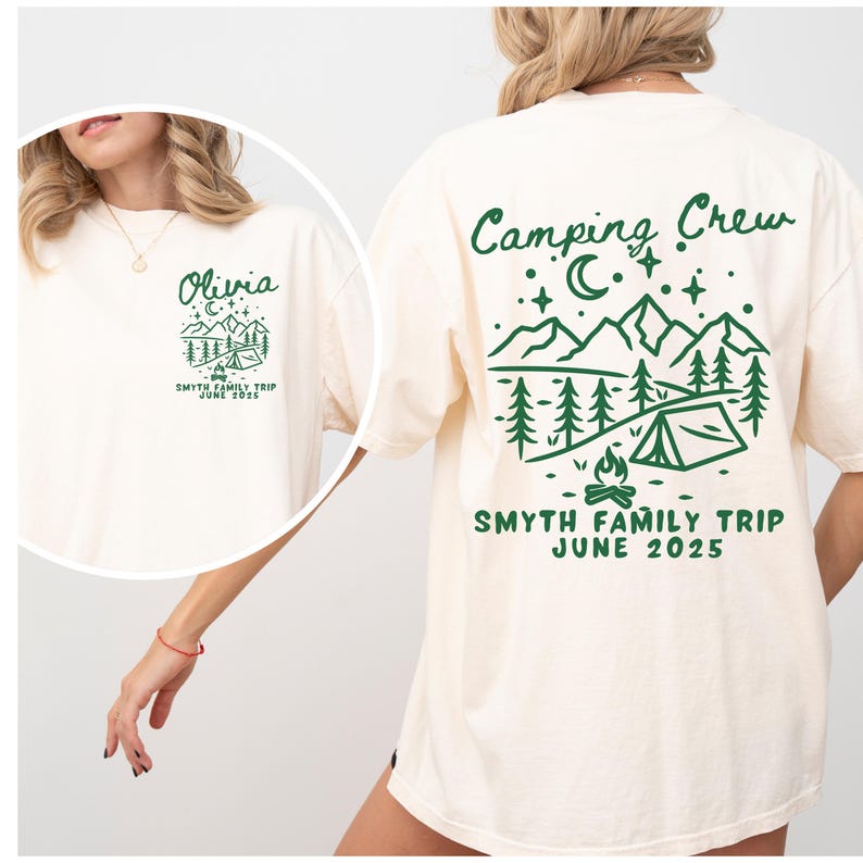 May include: A white t-shirt with a green camping crew design on the back. The design features mountains, trees, a tent, a campfire, and stars. The text "Camping Crew" is at the top of the design, and the text "Smyth Family Trip June 2025" is at the bottom. The front of the shirt has the name "Olivia" and the text "Smyth Family Trip June 2025" in green.