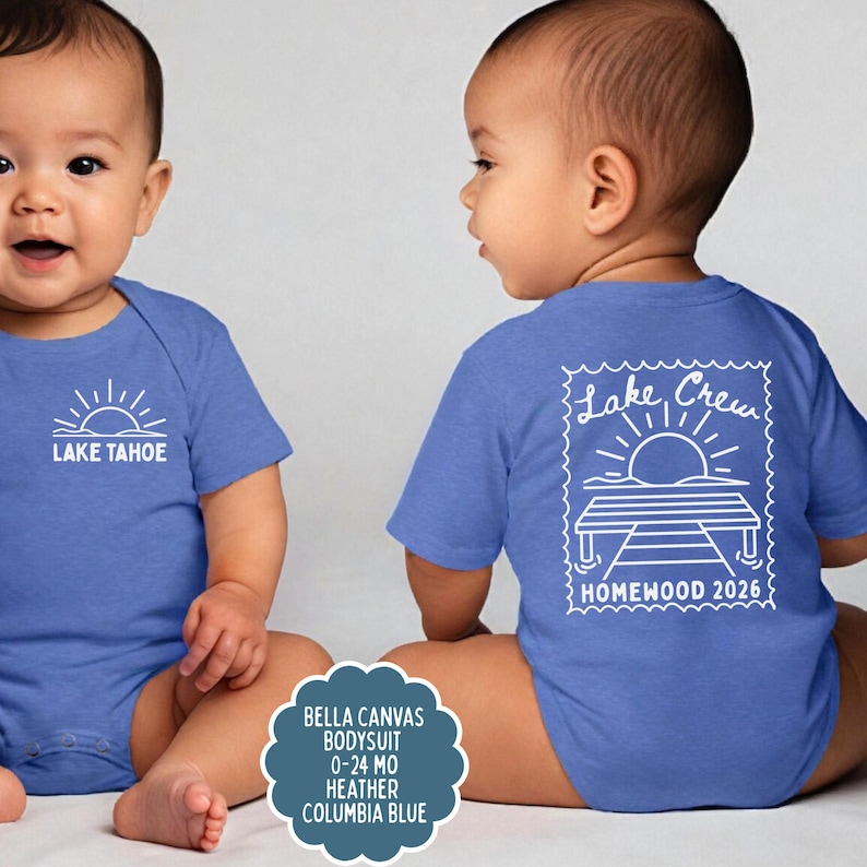 May include: A heather Columbia blue baby bodysuit featuring a white graphic of a sun over Lake Tahoe on the front and a larger white graphic of a sun over a dock with the text Lake Crew HOMEWOOD 2026 on the back, sized for 0-24 months.