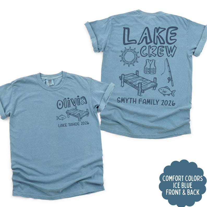 May include: Two ice blue t-shirts. One shirt has "Olivia" and "LAKE TAHOE 2026" printed on the front. The other shirt has "LAKE CREW" and "SMYTH FAMILY 2026" printed on the back, with lake-themed graphics. The shirts are Comfort Colors.