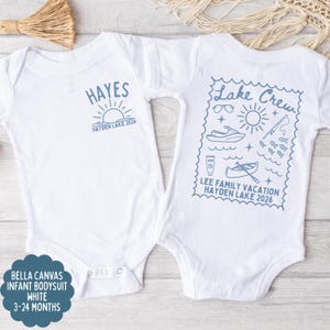 May include: Two white infant bodysuits. One has "HAYES" above a sun graphic and "HAYDEN LAKE 2026". The other has a "Lake Crew" design with vacation icons and "LEE FAMILY VACATION HAYDEN LAKE 2026".
