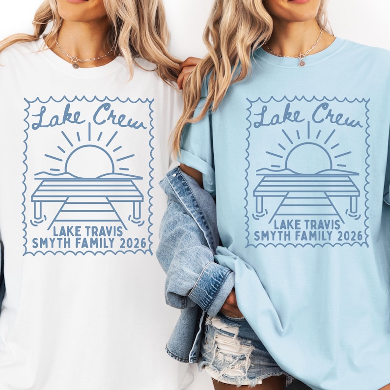 May include: A white t-shirt and a light blue t-shirt, each featuring a blue graphic of a sun rising over a dock inside a postage stamp border. The text reads Lake Crew, Lake Travis, and Smyth Family 2026 in a simple, clean font style.