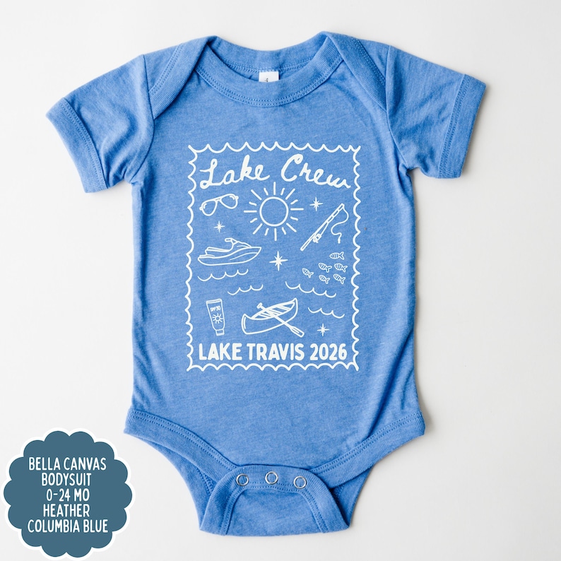 May include: A light blue baby bodysuit with a white graphic that says "Lake Crew" and features sunglasses, a sun, a jet ski, a fishing pole, fish, sunscreen, and a canoe. The text "Lake Travis 2026" is also included.