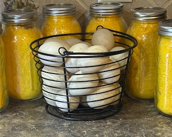 May include: Six glass jars filled with yellow powder, with a wire basket filled with white eggs in the center.