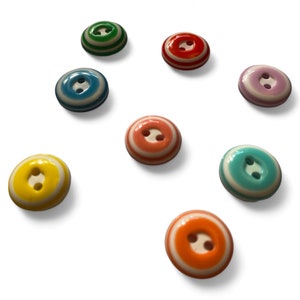 May include: Assortment of colourful striped buttons with two holes. The buttons are in shades of blue, green, yellow, orange, pink, and turquoise.