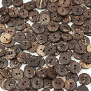 May include: A collection of brown coconut shell buttons with two holes each. The buttons are scattered on a white surface.