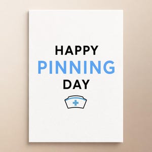 Może przedstawiać: Biała prostokątna kartka z czarnym napisem HAPPY, jasnoniebieskim napisem PINNING oraz czarnym napisem DAY. Poniżej tekstu znajduje się mała grafika przedstawiająca biały czepek pielęgniarski z jasnoniebieskim symbolem krzyża pośrodku.
