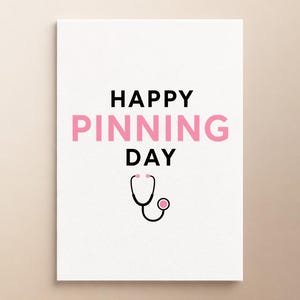 Może przedstawiać: Biała prostokątna kartka z czarnym napisem HAPPY i DAY oraz słowem PINNING zapisanym dużymi różowymi literami. Pod tekstem znajduje się prosta czarno-różowa graficzna ilustracja stetoskopu medycznego wyśrodkowana na kartce.