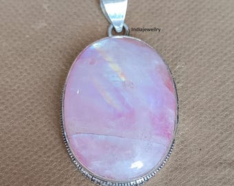 Op de afbeelding: Ovale hanger met een grote, iriserende roze edelsteen. De steen is gezet in een zilverkleurig metalen frame met een decoratieve rand en een lus voor een ketting. De hanger heeft een gepolijste afwerking en een neutrale achtergrond.