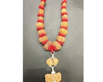 May include: A red string necklace with brown wooden beads and a silver pendant. The pendant is made of two brown wooden beads with a silver ring connecting them.