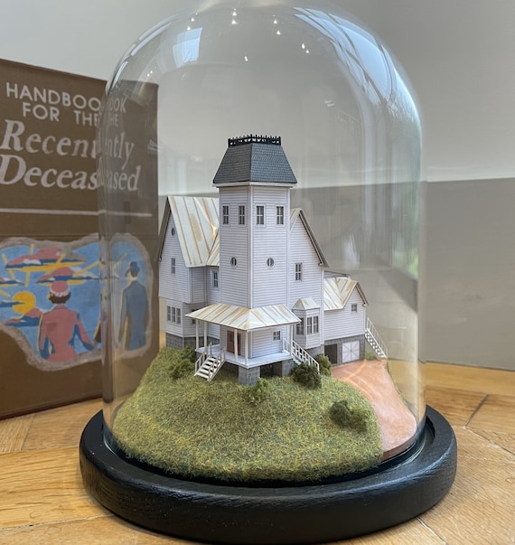 A jaw-dropping handmade Beetlejuice house miniature sealed under a glass dome cloche — 9,000+ favorites don't lie, this is the real deal.