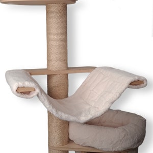 Könnte beinhalten: Ein beiger Katzenbaum mit einem Sisal-bekleideten Kratzbaum, einer Hängematte und einem Plüschbett. Die Hängematte ist aus weißem Kunstfell und das Bett ist beige.