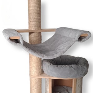Könnte beinhalten: Ein grauer Katzenbaum mit einer Hängematte, einem Bett und einem Kratzbaum. Die Hängematte und das Bett sind aus weichem, plüschem Stoff. Der Kratzbaum ist mit Sisal-Seil umwickelt.