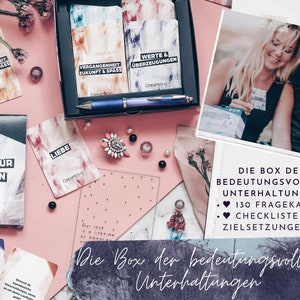 May include: A box of conversation starter cards with a pink background. The box contains 130 question cards and a checklist for goal setting. The text on the box reads "Die Box der bedeutungsvollen Unterhaltungen".