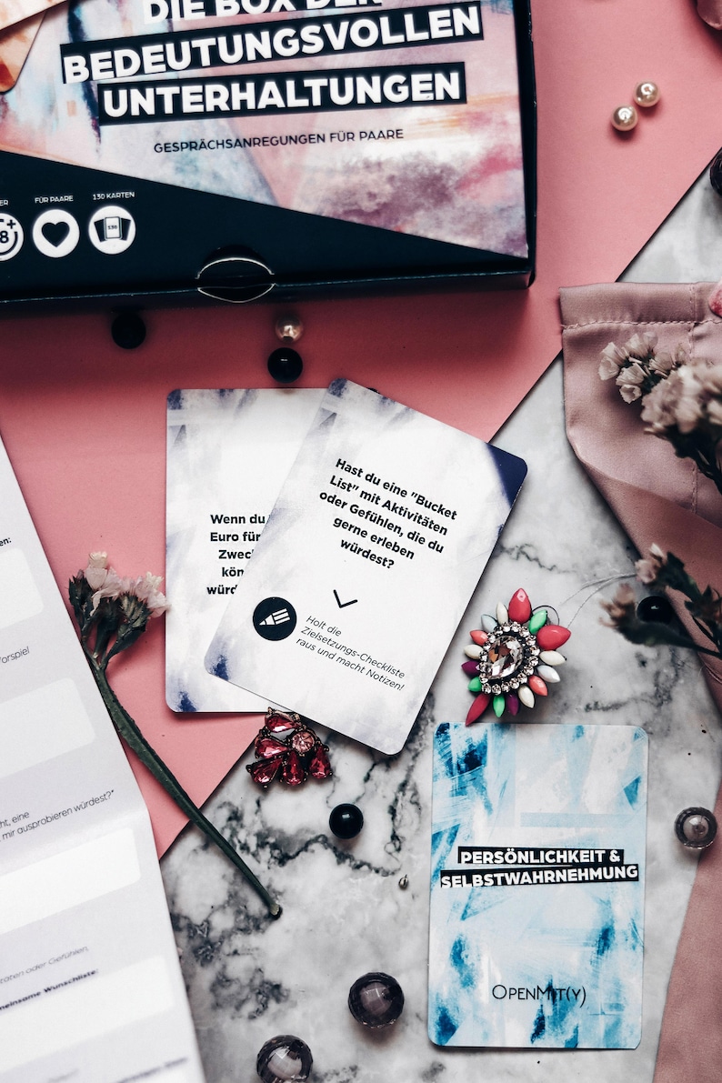May include: Two cards from a game called "The Box of Meaningful Conversations". The first card is white with black text that reads "If you had a million dollars, what would you do with it?" The second card is blue with white text that reads "Personality & Self-Awareness".