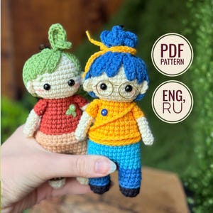 Peut inclure: Deux petites poupées au crochet avec des têtes rondes et des yeux en perles noires. La poupée de gauche a des cheveux verts et un haut rouge. Celle de droite a des cheveux bleus, un haut jaune et des lunettes dorées. Texte : PDF PATTERN ENG, RU.