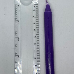 May include: A purple candle with a white wick, measuring approximately 7.5 cm in length.