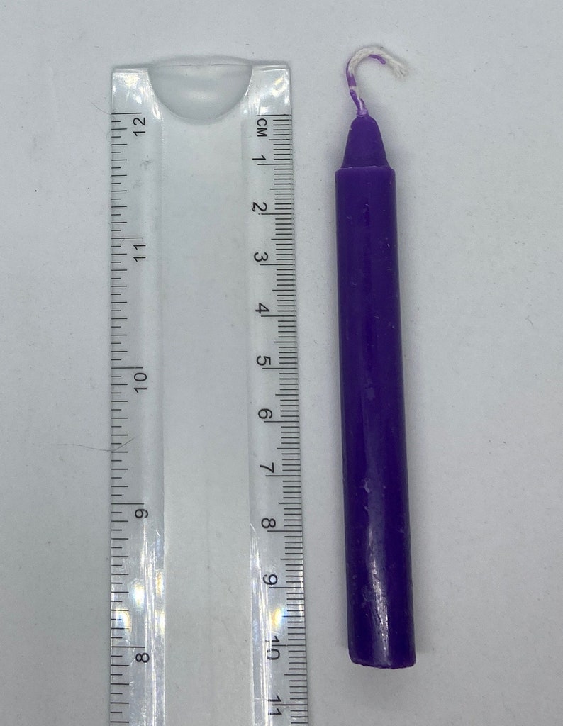 May include: A purple candle with a white wick, measuring approximately 7.5 cm in length.