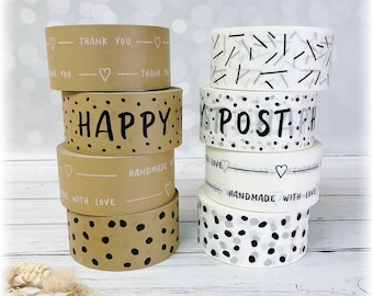 May include: A stack of four brown and white patterned washi tapes with the words "THANK YOU", "HAPPY", "POST", and "HANDMADE WITH LOVE" printed on them.