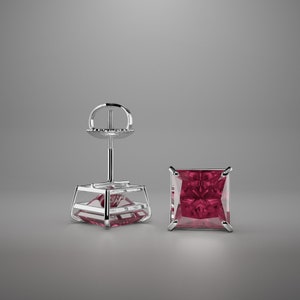 May include: A pair of silver stud earrings with a square-shaped, deep pink gemstone.