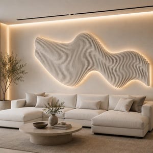 Peut inclure: Une grande sculpture murale beige à motif ondulé avec rétroéclairage intégré, fixée au-dessus d'un canapé d'angle crème. La pièce comprend une table basse ronde avec un petit vase, une plante en pot et des étagères intégrées avec décor.