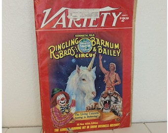 Könnte beinhalten: Ein rotes Variety-Magazincover mit einem weißen Einhorn, einem Clown, einem Tiger und dem Text "Kenneth Feld Presents The Greatest Show On Earth Ringling Bros. and Barnum & Bailey Circus".