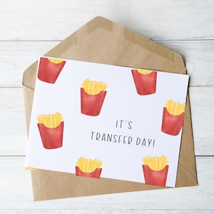 May include: A white card with a red and yellow french fry pattern. The card says "it's transfer day!"