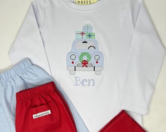May include: White long-sleeve shirt with an embroidered light blue car carrying gifts, a wreath, and the name "Ben". Includes red and light blue pajama pants. The shirt has a tag that says "three bees".