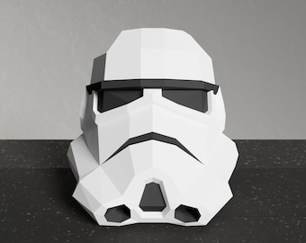 May include: A white, origami-style, Stormtrooper helmet with black details. The helmet has a black visor and a black mouth piece.