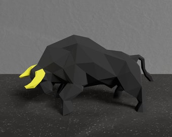 May include: A black origami bull sculpture with yellow horns. The bull is in a charging pose with its head lowered and its horns pointed forward.