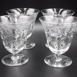 May include: Set of four clear glass stemmed dessert dishes with an etched floral design.