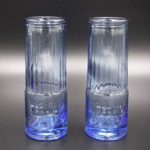 May include: Two blue glass shot glasses with the words "Tequila Correlejo" etched on the bottom.