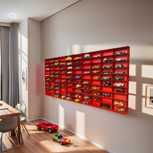 May include: A red wall shelf with multiple compartments filled with toy cars. The shelf is mounted on a white wall. There are three toy cars on the floor in front of the shelf.