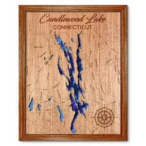 May include: Wooden framed map of Candlewood Lake, Connecticut. The lake is depicted in shades of blue, with surrounding roads and a compass rose. The text "Candlewood Lake CONNECTICUT" is at the top of the map.