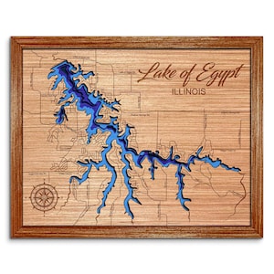 May include: A wooden map of Lake of Egypt in Illinois. The lake is shown in shades of blue, and the surrounding land is shown in brown. The map is framed in a dark wood frame.