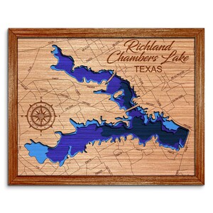 May include: Wooden framed map of Richland Chambers Lake in Texas, with a layered blue and brown design. The map includes a compass rose and the lake's name in elegant script.