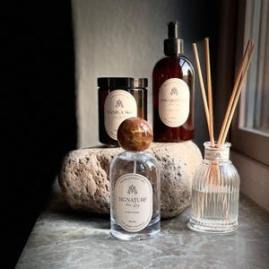 Mellby Atelier scented candle in a group with hand soap, room spray and reed diffuser.