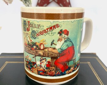 May include: A white ceramic mug with a brown rim and a vintage Christmas illustration of Santa Claus making toys in his workshop. The text "A Jolly Christmas" is printed on the mug.