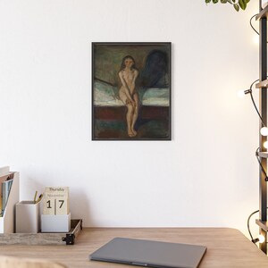 May include: A framed painting of a nude woman sitting on a bed. The woman has long dark hair and is looking directly at the viewer. The painting is done in a dark, muted palette with shades of brown, green, and blue. The painting is framed in a simple black frame.