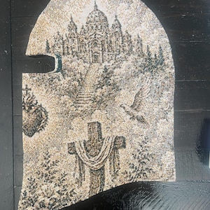 May include: A woven balaclava featuring a detailed tapestry-style design in shades of beige, brown, and black. The pattern depicts a large domed building on a hill, a cross draped with fabric, a flying bird, and a heart-shaped emblem on the side.