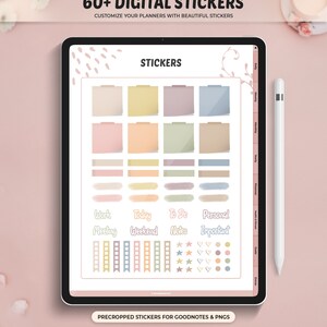May include: A digital tablet showing digital stickers for planners. The stickers are in pastel shades and include sticky notes, labels, and icons. Text on the screen reads "60+ DIGITAL STICKERS" and "STICKERS". A white stylus is next to the tablet.