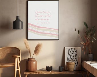 May include: A rectangular wall art print featuring the text "Come to me, all you who are weary, MATTHEW 11:28" in pink script. The design includes wavy horizontal bands in shades of pink and beige with a dotted pattern on a white background.